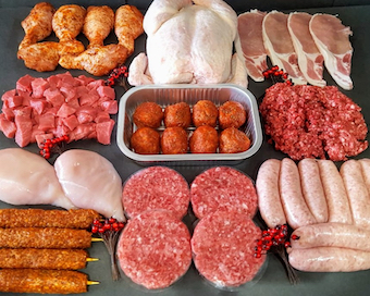 A selection of fresh meat from Reynolds Butchers including whole chicken, sausages, burgers, mince, and prepared cuts.